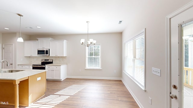 3725 Huntcliff Dr, La Grange, NC 28551 - kitchen with appliances with stainless steel finishes, a sink, light wood-style floors, light countertops, and backsplash