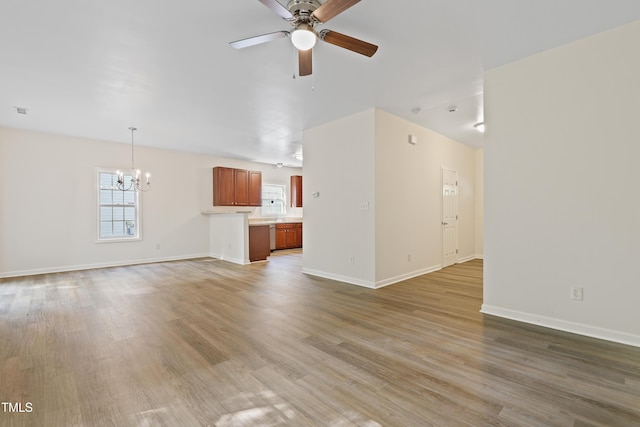 3223 Polite Ln, Raleigh, NC 27610 - unfurnished living room with a chandelier, ceiling fan, light wood-style flooring, and baseboards