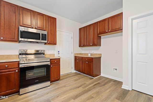 3223 Polite Ln, Raleigh, NC 27610 - kitchen featuring stainless steel appliances, light wood-type flooring, light countertops, and baseboards