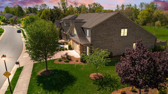 view of property exterior with a yard, driveway, and a garage