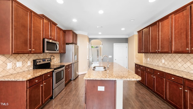kitchen with a sink, crown molding, dark wood-style flooring, arched walkways, and appliances with stainless steel finishes