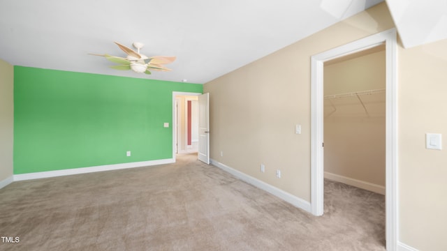 unfurnished bedroom with baseboards, a spacious closet, a closet, and carpet