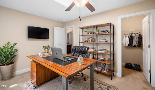 office area featuring ceiling fan, light carpet, and baseboards