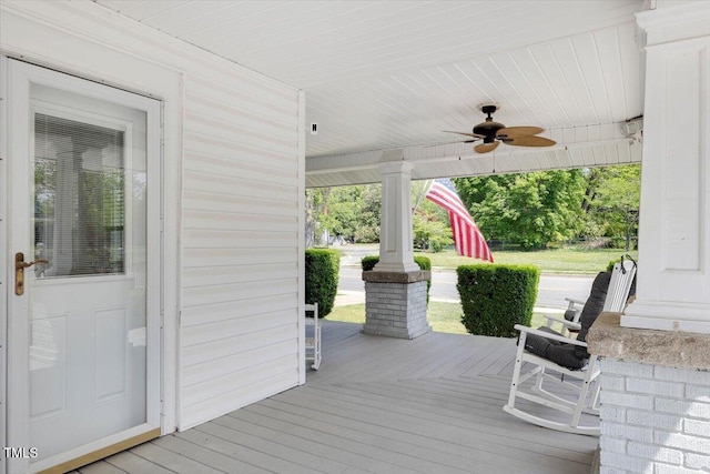 wooden terrace with a porch and ceiling fan