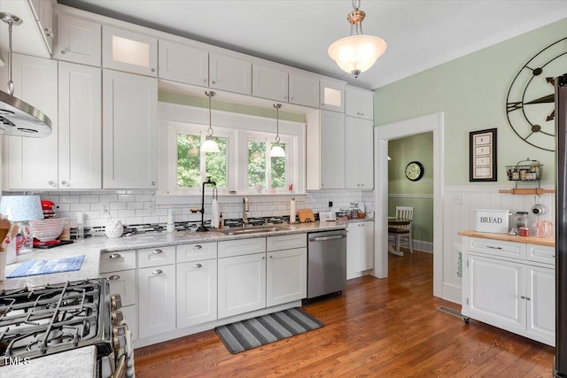 kitchen with appliances with stainless steel finishes, white cabinetry, a sink, glass insert cabinets, and light wood-style flooring