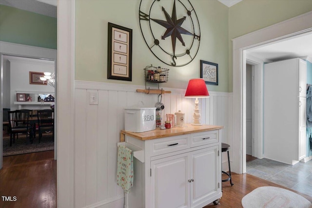 corridor featuring wood finished floors and a wainscoted wall