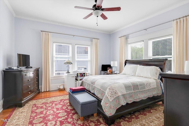 bedroom featuring crown molding, a ceiling fan, baseboards, and wood finished floors