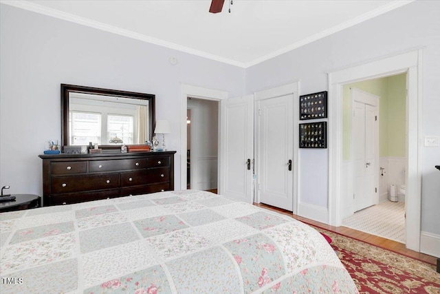 bedroom featuring crown molding, ceiling fan, wood finished floors, and ensuite bathroom
