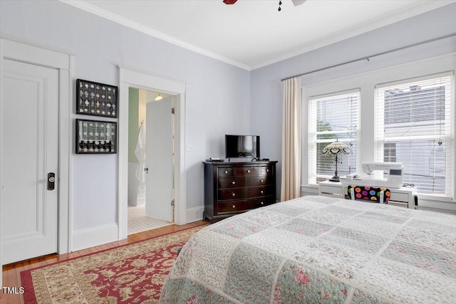 bedroom featuring crown molding, connected bathroom, a ceiling fan, baseboards, and wood finished floors