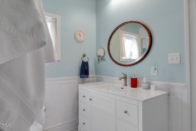 bathroom with vanity, plenty of natural light, and a wainscoted wall