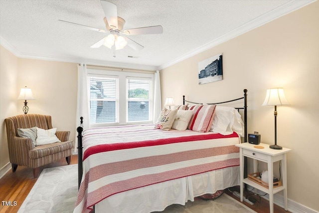 bedroom with crown molding, a ceiling fan, a textured ceiling, and wood finished floors
