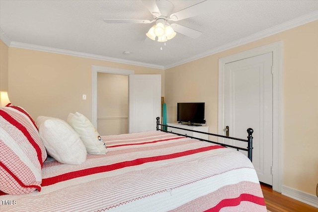 bedroom featuring baseboards, ornamental molding, a ceiling fan, and wood finished floors