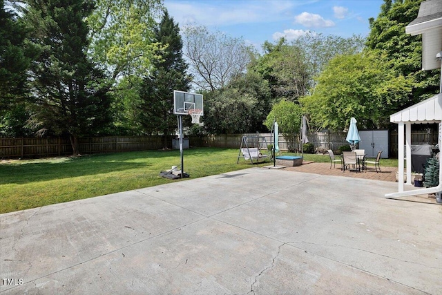 view of sport court with a lawn and a fenced backyard