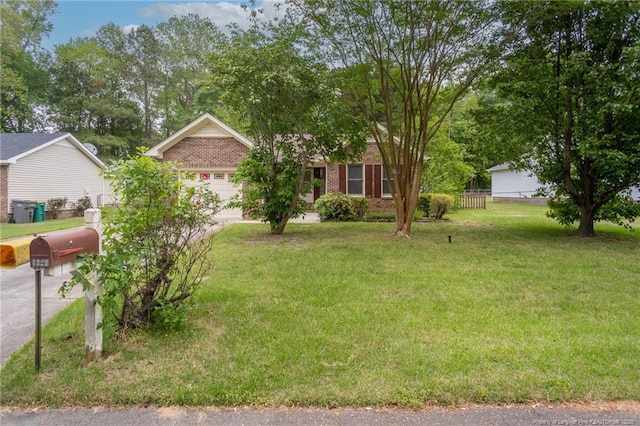 view of front of home featuring driveway, a front yard, a garage, brick siding, and fence