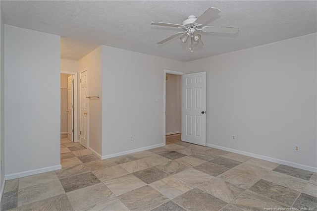 spare room with a textured ceiling, ceiling fan, and stone finish flooring