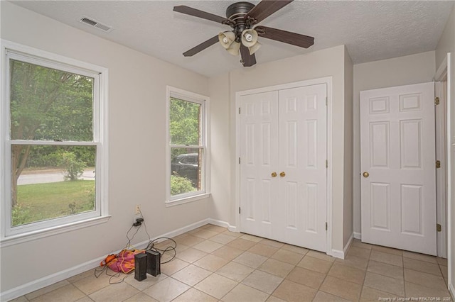 unfurnished bedroom featuring baseboards, light tile patterned flooring, and a closet
