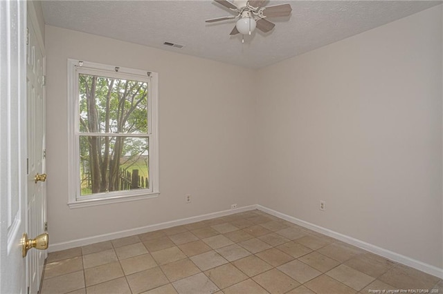 unfurnished room featuring baseboards, ceiling fan, a textured ceiling, and visible vents