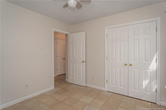 unfurnished bedroom featuring baseboards, a textured ceiling, light tile patterned flooring, and a closet