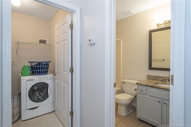 full bath featuring washer / clothes dryer, a textured ceiling, visible vents, and vanity