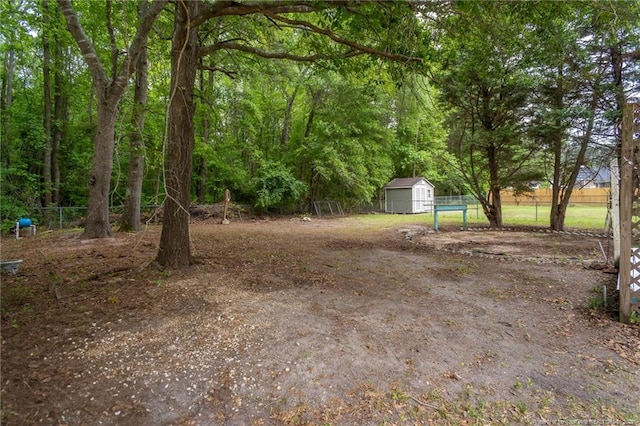 view of yard with a storage shed, fence, and an outbuilding