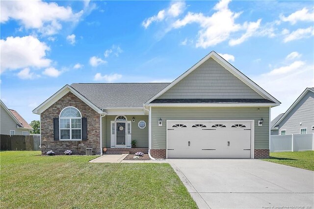 view of front of home featuring an attached garage, fence, driveway, and a front yard