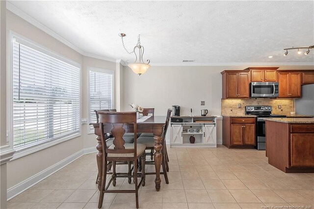 dining space featuring light tile patterned flooring, a textured ceiling, plenty of natural light, and ornamental molding