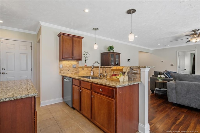 kitchen featuring decorative backsplash, a peninsula, open floor plan, a sink, and dishwasher