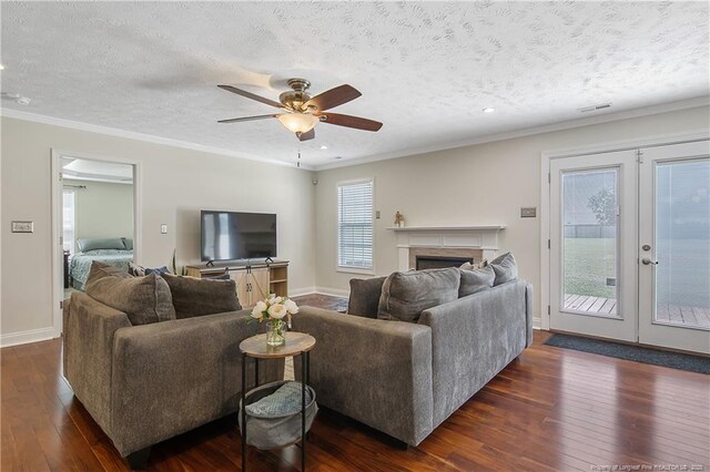 living area with ceiling fan, dark wood finished floors, ornamental molding, and french doors