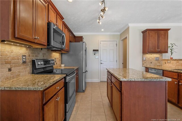 kitchen with decorative backsplash, a kitchen island, light stone counters, light tile patterned floors, and stainless steel appliances