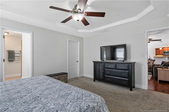 bedroom featuring crown molding, a tray ceiling, and carpet flooring