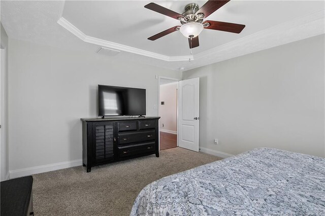 bedroom with crown molding, baseboards, carpet, and a raised ceiling