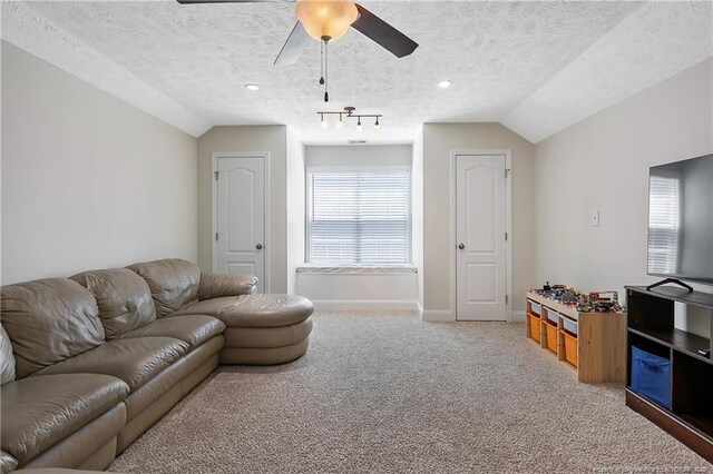 living area featuring a textured ceiling, ceiling fan, light carpet, and lofted ceiling
