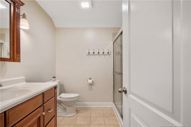 bathroom with a stall shower, vanity, baseboards, tile patterned floors, and toilet
