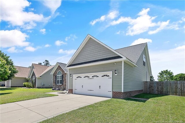 view of front of home featuring a garage, a front lawn, fence, and driveway