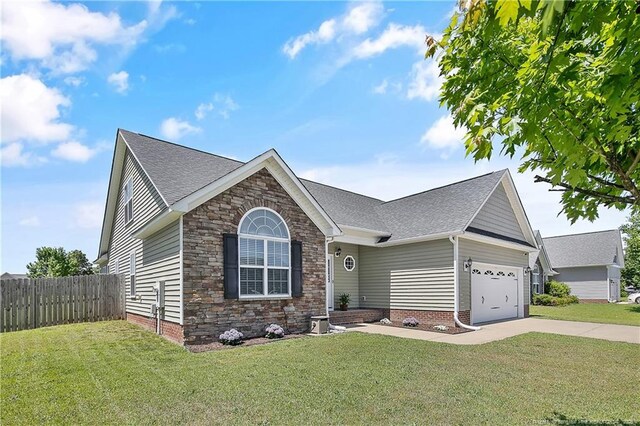 view of front of home with a garage, a front lawn, fence, and driveway