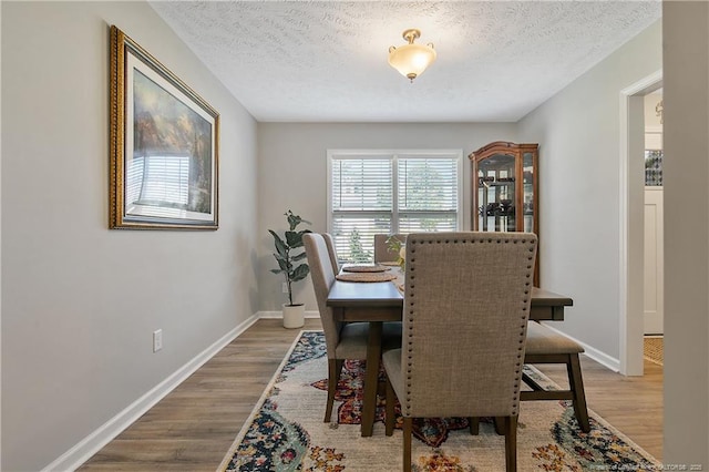 4631 Cedar Pass Dr, Hope Mills, NC 28348 - dining space featuring baseboards, a textured ceiling, and wood finished floors