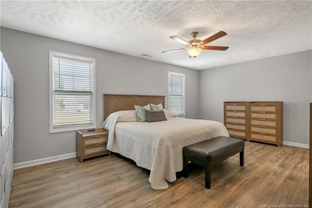 4631 Cedar Pass Dr, Hope Mills, NC 28348 - bedroom with baseboards, a textured ceiling, and light wood-style flooring