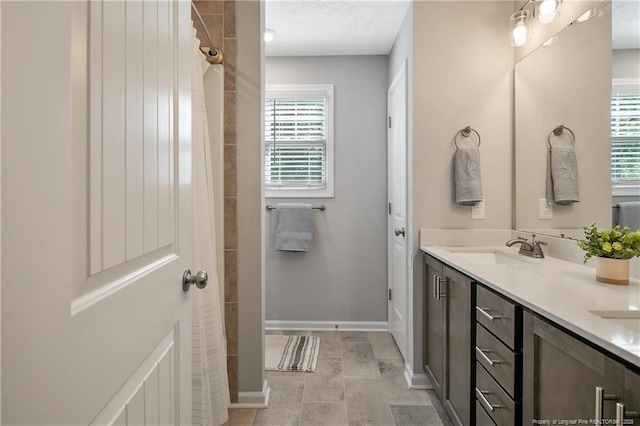 4631 Cedar Pass Dr, Hope Mills, NC 28348 - bathroom featuring baseboards, a sink, a healthy amount of sunlight, and a tile shower