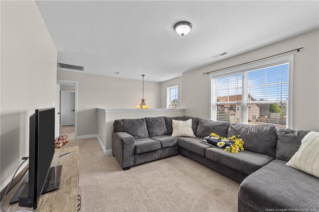 living area with visible vents, baseboards, and light colored carpet