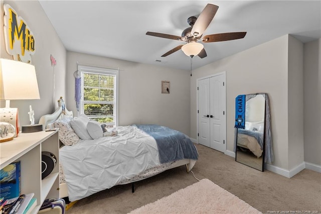 carpeted bedroom featuring baseboards, ceiling fan, and a closet