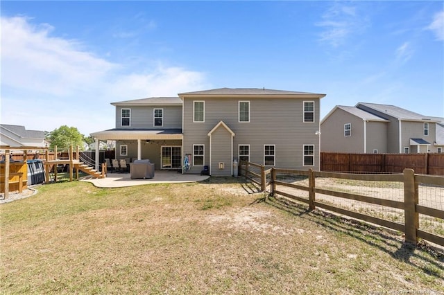 back of property with a lawn, a fenced backyard, and a patio area