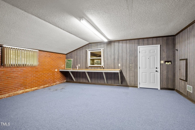 bonus room with lofted ceiling, carpet flooring, a textured ceiling, and visible vents