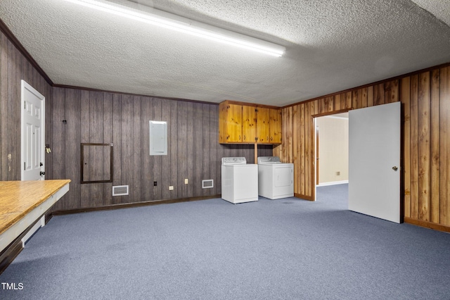 below grade area with visible vents, a textured ceiling, and washer and dryer