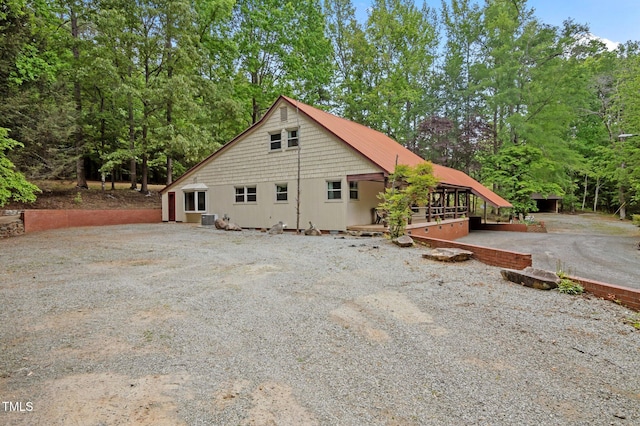 exterior space featuring central air condition unit and gravel driveway