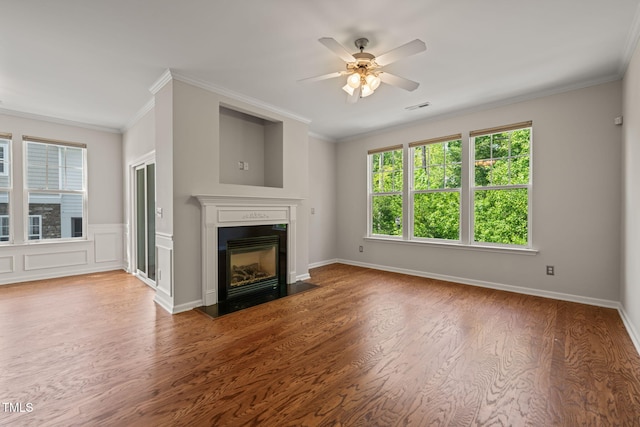 unfurnished living room featuring visible vents, a ceiling fan, wood finished floors, and a wealth of natural light