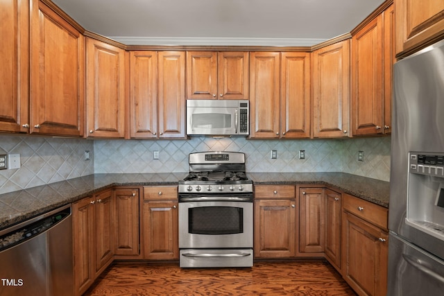 kitchen featuring appliances with stainless steel finishes, brown cabinets, and dark wood-type flooring