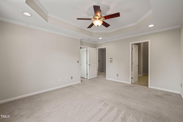 unfurnished bedroom with recessed lighting, light colored carpet, ornamental molding, and a raised ceiling