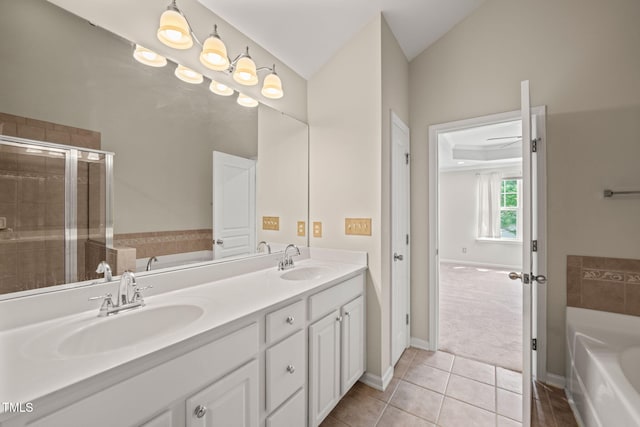 bathroom with double vanity, tile patterned floors, a sink, and a garden tub