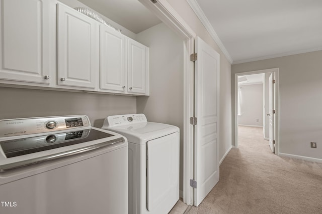 laundry area with washing machine and clothes dryer, cabinet space, baseboards, ornamental molding, and light carpet