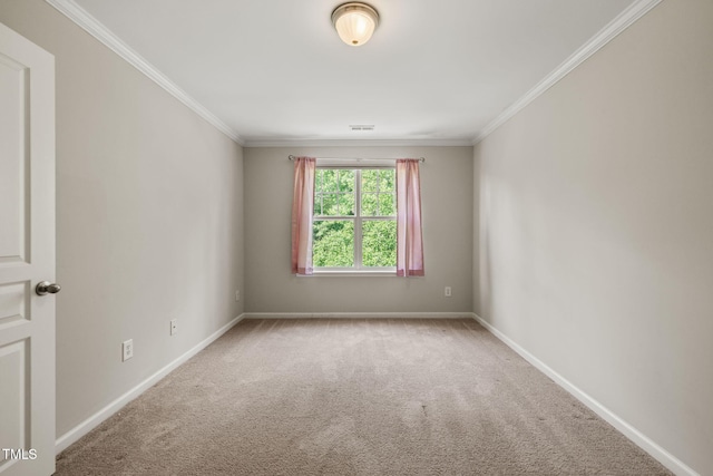 carpeted spare room with baseboards, ornamental molding, and visible vents